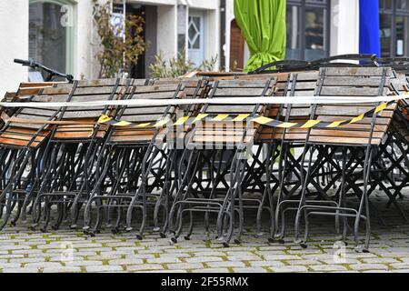 Munich, Allemagne. 23 mars 2021. Sujet: Pandémie de coronavirus/conséquences pour la gastronomie: Chaises empilées et pliées devant un restaurant, gastronomie en plein air le 23 mars 2021. | utilisation dans le monde crédit: dpa/Alay Live News Banque D'Images