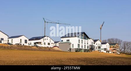 Allemagne, Bade-Wurtemberg, Waiblingen, Panorama de banlieue moderne à haut rendement énergétique avec grues industrielles en arrière-plan Banque D'Images