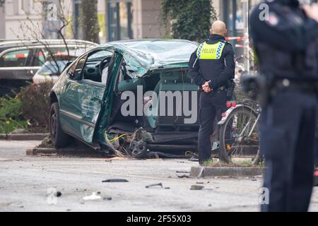 Hambourg, Allemagne. 24 mars 2021. Un policier regarde le véhicule détruit. Après la collision avec un véhicule sur une intersection, la voiture a été déchirée en deux et la conductrice a subi des blessures mortelles, selon la police. Le passager de l'autre voiture de tourisme a subi un choc. Credit: Jonas Walzberg/dpa - ATTENTION: Personne(s) et plaque(s) d'immatriculation de voiture ont été pixelisés pour des raisons juridiques/dpa/Alay Live News Banque D'Images