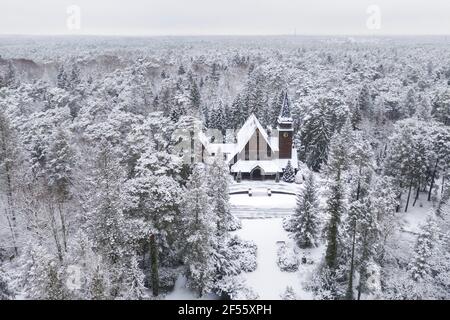 Allemagne, Brandebourg, Stahnsdorf, Drone vue de l'église éloignée dans la forêt enneigée Banque D'Images