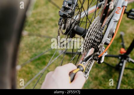 Gros plan d'un mécanicien de vélo avec un tournevis pour réparer un vélo Banque D'Images