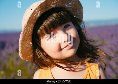 Portrait d'une petite fille mignonne portant un chapeau de paille debout à l'extérieur Banque D'Images