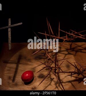 Arrière-plan rustique de Pâques avec couronne d'épines, oeuf rouge et croix en bois noir image horizontale Banque D'Images