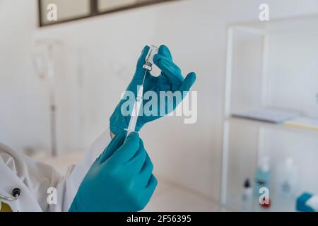 Gros plan de la seringue remplie par le médecin avec le vaccin COVID-19 lors de l'examen chambre Banque D'Images