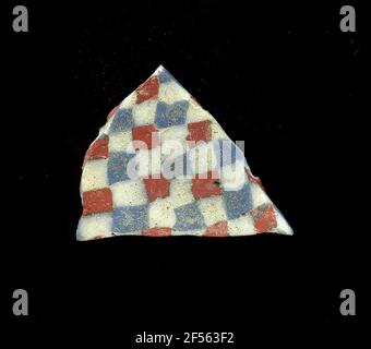 Fragment d'un vaisseau. Une faible courbure du fragment de verre permet l'affectation à un vaisseau, éventuellement à une coque. Le verre présente un motif de damier blanc, bleu et rouge. Pour la production, des verres de différentes couleurs ont été façonnés sur des tubes et des tiges. Elles étaient comprimées et chauffées, ce qui entraînait une longue barre. Le verre coupé en tranches de ​​now avait des motifs amorphes ou floraux différents. Par la suite, plusieurs de ces plaquettes ont été repliées ensemble, réchauffées à nouveau et pressées en forme vasculaire. Burry pour le processus de fabrication élaboré et sa fragilité a été l'un des articles de luxe de l'antiquité. Banque D'Images