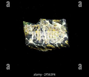 Fragment d'un vaisseau. Une faible courbure du fragment de verre permet l'affectation à un vaisseau, éventuellement à une coque. Le sol violet est traversé par une grille de lignes blanches rappelant les nids d'abeilles. Dans les champs, on peut voir des fleurs dans la technologie millefiori. Pour obtenir un point jaune d'autres points jaunes comme pétales. Une autre fleur peut être vue au bord de la fracture : un demi-cercle avec des lignes jaunes et bleues. Pour la production, des verres de différentes couleurs ont été façonnés sur des tubes et des poteaux. Elles étaient comprimées et chauffées, ce qui entraînait une longue barre. Le verre coupé en tranches de ​​now avait des motifs amorphes ou floraux différents Banque D'Images