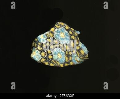 Fragment d'un vaisseau. Une faible courbure du fragment de verre permet l'affectation à un vaisseau, éventuellement à une coque. Le sol violet est traversé par de fines lignes blanches, qui forment une grille, le nid d'abeille ressemble. Dans les espaces sont des fleurs composées d'un point jaune pour poser les points bleus bordés de blanc comme des pétales. Par conséquent, plus de points jaunes sur une raison violette peuvent être vus sur une ligne circulaire. Pour la production, des verres de différentes couleurs ont été façonnés sur des tubes et des tiges. Elles étaient comprimées et chauffées, ce qui entraînait une longue barre. Le verre coupé en tranches de ​​now avait des motifs amorphes ou floraux différents. Par la suite, se Banque D'Images