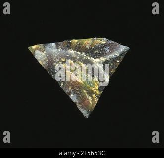 Fragment d'un vaisseau. Le petit fragment de verre montre plusieurs fleurs dans la technologie Millefiori sur la raison rouge foncé. Elles sont délimitées par des lignes blanches. Afin de poser un noyau vert ou jaune irrégulièrement comme des pétales. Pour la production, des verres de différentes couleurs ont été façonnés sur des tubes et des tiges. Elles étaient comprimées et chauffées, ce qui entraînait une longue barre. Le ​​now en verre tranché avait une grande variété de motifs amorphes ou floraux. Banque D'Images