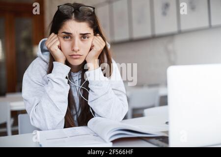 Portrait de bouleversé et fatigué jeune belle femme avec de longs cheveux foncés se préparant à passer et examen étudiant toute la nuit. Banque D'Images