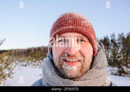 Homme moyen adulte visage couvert de neige pendant l'hiver Banque D'Images