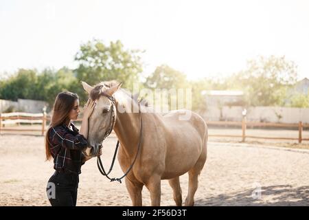 Jeune femme propriétaire de cheval faisant une promenade avec un animal sur une ferme ou un ranch. Concept de liberté. Banque D'Images