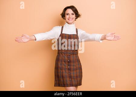 Photo portrait de jeune modèle souriant invitant heureux de voir réunion de bienvenue isolée sur fond de couleur beige pastel Banque D'Images