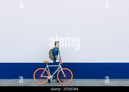 Homme avec vélo marchant sur le sentier Banque D'Images