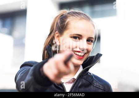Portrait d'une jeune belle blonde pointant vers l'appareil photo Banque D'Images