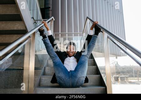 Danse professionnelle masculine avec jambes relevées sur l'escalier Banque D'Images