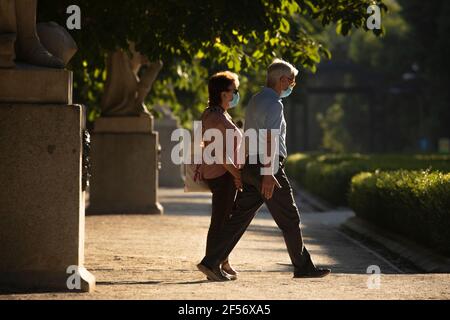 Madrid, Espagne - 20 juin 2020 : un homme adulte et une femme marchent dans le parc du Retiro, se tenant les mains, dans la zone de la promenade de la statue, en profitant de Tim libre Banque D'Images