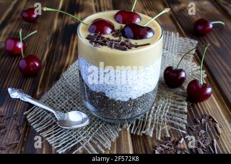 Pudding avec de la pâte de chia, de cerise et d'arachide sur le bois rustique arrière-plan Banque D'Images