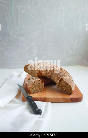 Un pain de seigle fraîchement cuit sur une planche à découper en bois. Pain de levain de seigle maison. Banque D'Images