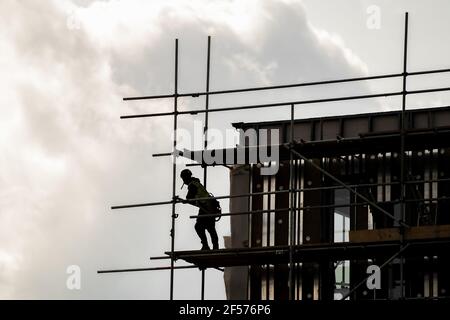 Échafaudage de silhouette dans le cadre de construction d'EPI de planches en bois et de grands poteaux d'échafaudage en hauteur sur le site de construction moderne d'un nouveau bâtiment. Regarder Banque D'Images