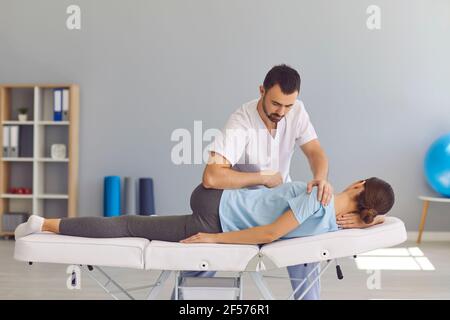 Homme confiant médecin chiropracteur ou ostéopathe fixant les womans dos et articulations des jambes Banque D'Images