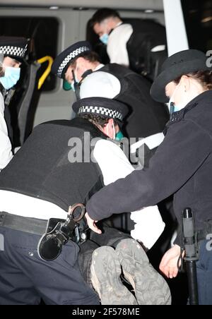 Un manifestant contre le climat est placé dans un véhicule de police après s'être fixé aux portes devant Downing Street à Westminster, Londres. Date de la photo: Mercredi 24 mars 2021. Banque D'Images