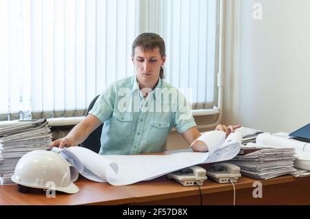 Homme ingénieur qualifié dans la conception structurelle travaillant sur le détail rapport de projet dans un bureau Banque D'Images