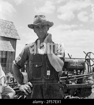 Ancien agriculteur locataire d'une grande ferme de coton maintenant un conducteur de tracteur pour un dollar par jour sur la même ferme. Comté de Bell, Texas. Juin 1937. Photo de Dorothea Lange. Banque D'Images