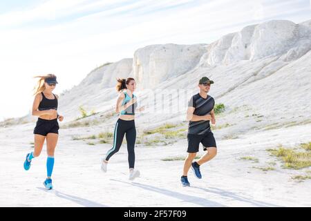 Groupe de coureurs courent à l'extérieur le long de la falaise blanche Banque D'Images