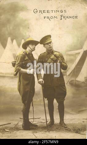 « salutations de France » la carte postale de la première Guerre mondiale montre un soldat britannique et du commonwealth symboliquement debout devant un fond peint avec des tentes blanches. Uniformes de couleur verte sur monochrome. Banque D'Images