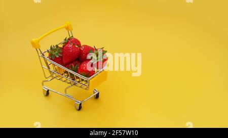 Fraises fraîches dans un panier sur un jaune vif arrière-plan Banque D'Images