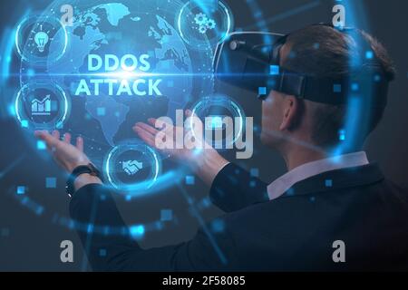Concept commercial, technologique, Internet et réseau. Jeune homme d'affaires travaillant sur un écran virtuel du futur et voit l'inscription: Attaque DDoS Banque D'Images