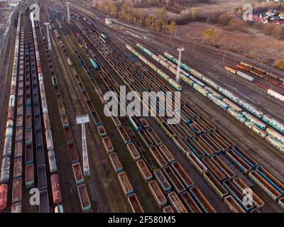 Drone a tiré sur une gare de triage avec des trains au coucher du soleil. Photo voies de chemin de fer avec wagons, vue de dessus. Vue de dessus de l'antenne. Banque D'Images