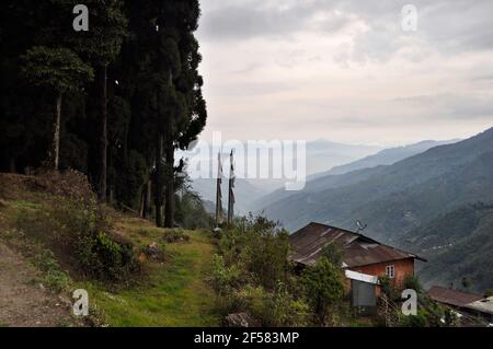 Cottage sur le sommet d'une colline avec vue sur les rangées de crêtes et vallée avec ciel nuageux et forêt de pins Banque D'Images