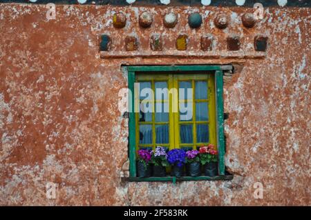 Mur en pierre rouge monasry de Budhist, très décoré, de couleur verte fenêtre avec pot de fleurs Banque D'Images