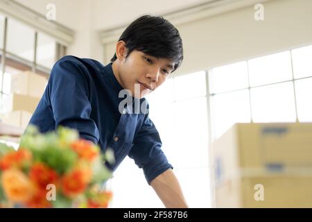 Jeune homme lance une petite entreprise (PME) en livrant des produits emballés dans des boîtes par le biais d'un système logistique depuis le bureau à domicile, la livraison de colis, en ligne m Banque D'Images