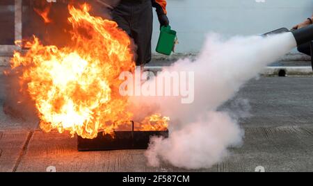 L'homme enseigne ou forme à utiliser des extincteurs au dioxyde de carbone (CO2) pour éteindre les incendies de carburant. Banque D'Images