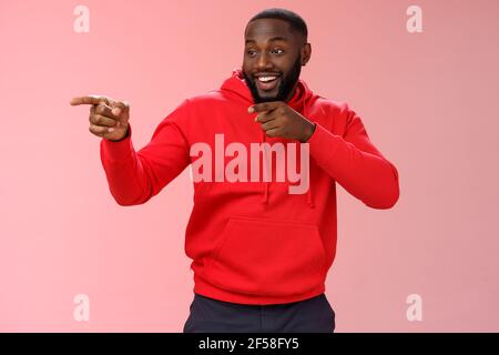 Hé, je te tiens. Portrait triché confiant afro-américain sortant barbu entrée dans le club voir les amis faire bonjour geste pointant vers la gauche Banque D'Images