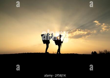 Ville de Pleiku, province de Gia Lai, Vietnam - 6 mars 2021 : deux agriculteurs de l'Ede collectent du bois de chauffage sur leur chemin, au coucher du soleil, dans la ville de Pleiku, province de Gia Lai, Banque D'Images