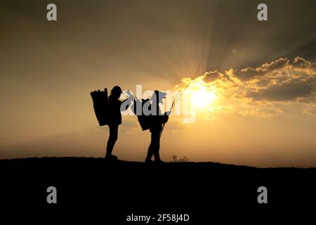 Ville de Pleiku, province de Gia Lai, Vietnam - 6 mars 2021 : deux agriculteurs de l'Ede collectent du bois de chauffage sur leur chemin, au coucher du soleil, dans la ville de Pleiku, province de Gia Lai, Banque D'Images