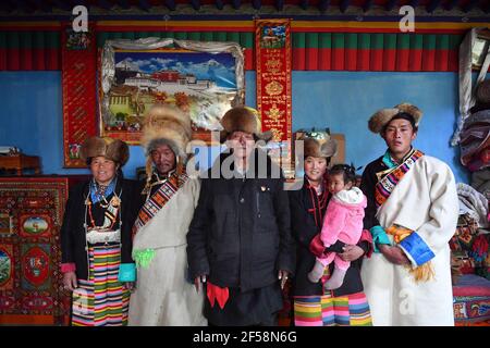 (210325) -- LHASSA, 25 mars 2021 (Xinhua) -- photo prise le 21 mars 2021 montre Basang (3e L) posant pour des photos avec sa famille à la maison dans le village de Taye de Xigaze, dans le sud-ouest de la Chine, région autonome du Tibet. Basang, né en 1934, est un villageois du village de Taye à Xigaze, la région autonome du Tibet en Chine.dans le passé, la famille de Basang a dû payer divers impôts aux propriétaires de sérès, ce qui a fait la famille mener une vie misérable. « le nombre de taxes que nous avons payées était encore plus que des ondulations dans l'eau et des étoiles dans le ciel », a rappelé Basang. La nouvelle vie a commencé à embrasser la famille de Basang en 1959, après Banque D'Images