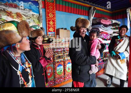 (210325) -- LHASSA, 25 mars 2021 (Xinhua) -- Basang (C) s'entretient avec sa famille à son domicile, dans le village de Taye de Xigaze, dans la région autonome du Tibet du sud-ouest de la Chine, le 21 mars 2021. Basang, né en 1934, est un villageois du village de Taye à Xigaze, la région autonome du Tibet en Chine.dans le passé, la famille de Basang a dû payer divers impôts aux propriétaires de sérès, ce qui a fait la famille mener une vie misérable. « le nombre de taxes que nous avons payées était encore plus que des ondulations dans l'eau et des étoiles dans le ciel », a rappelé Basang. La nouvelle vie a commencé à embrasser la famille de Basang en 1959, après qu'une réforme démocratique a libéré M. Banque D'Images