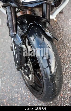 Garde-boue avant en plastique cassé de la moto en raison d'un accident de la route, vue rapprochée Banque D'Images