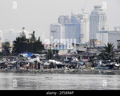 Photo prise le 26 janvier 2021, montre des maisons le long de la rivière Pasig à Manille, avec des immeubles en hauteur vus en arrière-plan. (Kyodo)==Kyodo photo via crédit: Newscom/Alay Live News