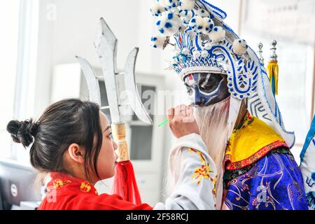 Longli, province chinoise du Guizhou. 23 mars 2021. Un étudiant dessine le maquillage facial avant la répétition à l'école secondaire n° 3 du comté de Longli, Qiannan Buyi et préfecture autonome de Miao, province de Guizhou, dans le sud-ouest de la Chine, le 23 mars 2021. Afin de transmettre et de protéger l'opéra traditionnel Taiping Huadengxi du comté de Longli, la Middle School no 3 du comté de Longli a invité les héritiers de l'opéra à donner des leçons régulières aux élèves. Credit: Yang Wenbin/Xinhua/Alamy Live News Banque D'Images