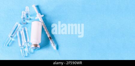 Ampoules médicales pour injection, flacon et seringue sur fond bleu. Ampoules en verre et flacons de médicaments sur la table. Médicaments et traitement des maladies Banque D'Images