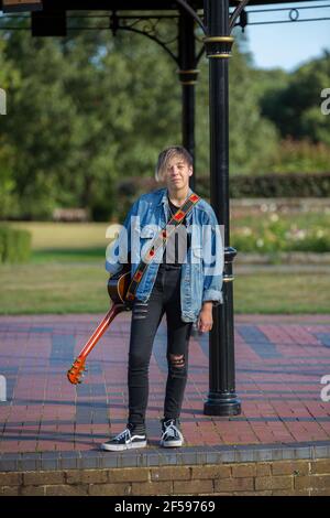 Woodbridge, Suffolk, Royaume-Uni septembre 13 2020: Une femme de 20 quelque chose de relaxant et posant avec sa guitare acoustique Banque D'Images