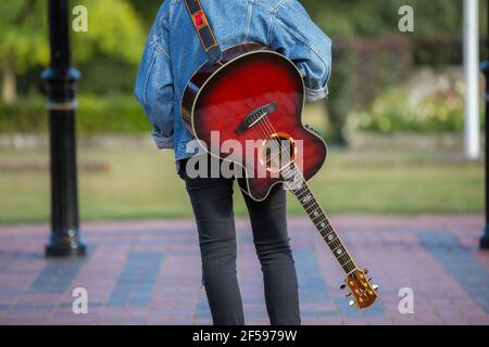 Woodbridge, Suffolk, Royaume-Uni septembre 13 2020: Une femme de 20 quelque chose de relaxant et posant avec sa guitare acoustique Banque D'Images