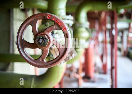 Fermeture de vanne verte rétro de type pétrochimique industriel avec sélective concentrez-vous sur le volant marron avec connexion à bride activée vert Banque D'Images