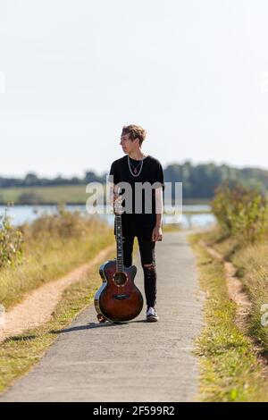 Woodbridge, Suffolk, Royaume-Uni septembre 20 2020: Une femme de 20 quelque chose de relaxant et posant avec sa guitare acoustique Banque D'Images