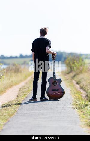 Woodbridge, Suffolk, Royaume-Uni septembre 20 2020: Une femme de 20 quelque chose de relaxant et posant avec sa guitare acoustique Banque D'Images